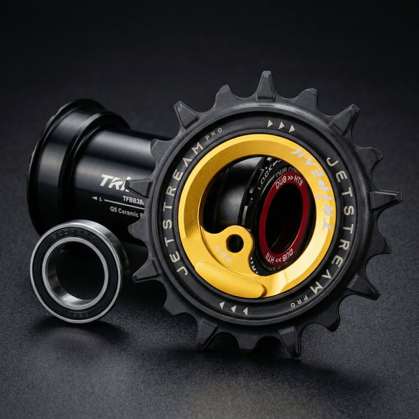 Close-up of a bicycle gear system with 'TRIPEAK' branding on a dark background